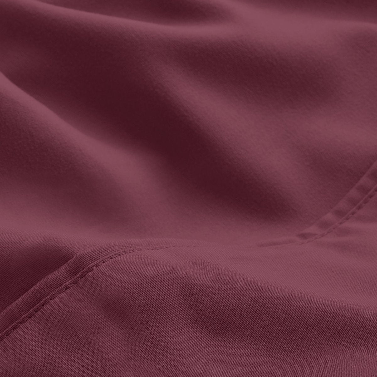 A close-up of microfiber fabric with soft folds and a visible stitched seam.