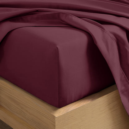 Close up of the corner of a mattress with a fitted sheet and flat sheet on it