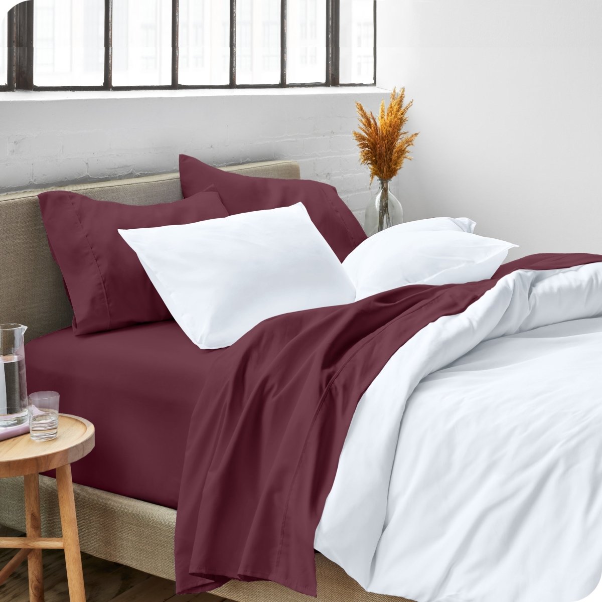 A side view of a bed made with microfiber sheets and a white duvet cover