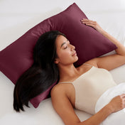 Woman lying on a bed with a pillow covered with a satin pillowcase