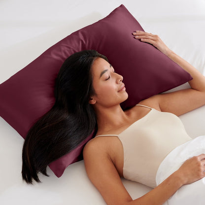 Woman lying on a bed with a pillow covered with a satin pillowcase