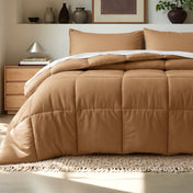 Comforter on a bed in a bedroom setting with a wooden nightstand and decorative items.