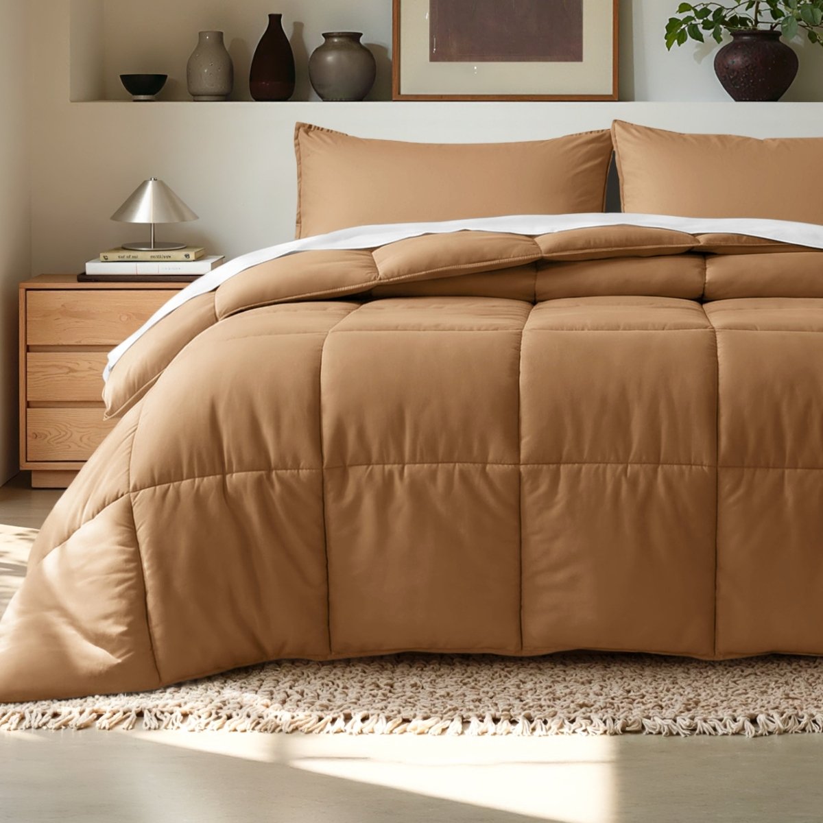 Comforter on a bed in a bedroom setting with a wooden nightstand and decorative items.