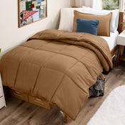 Bed with comforter and pillows in a dorm room