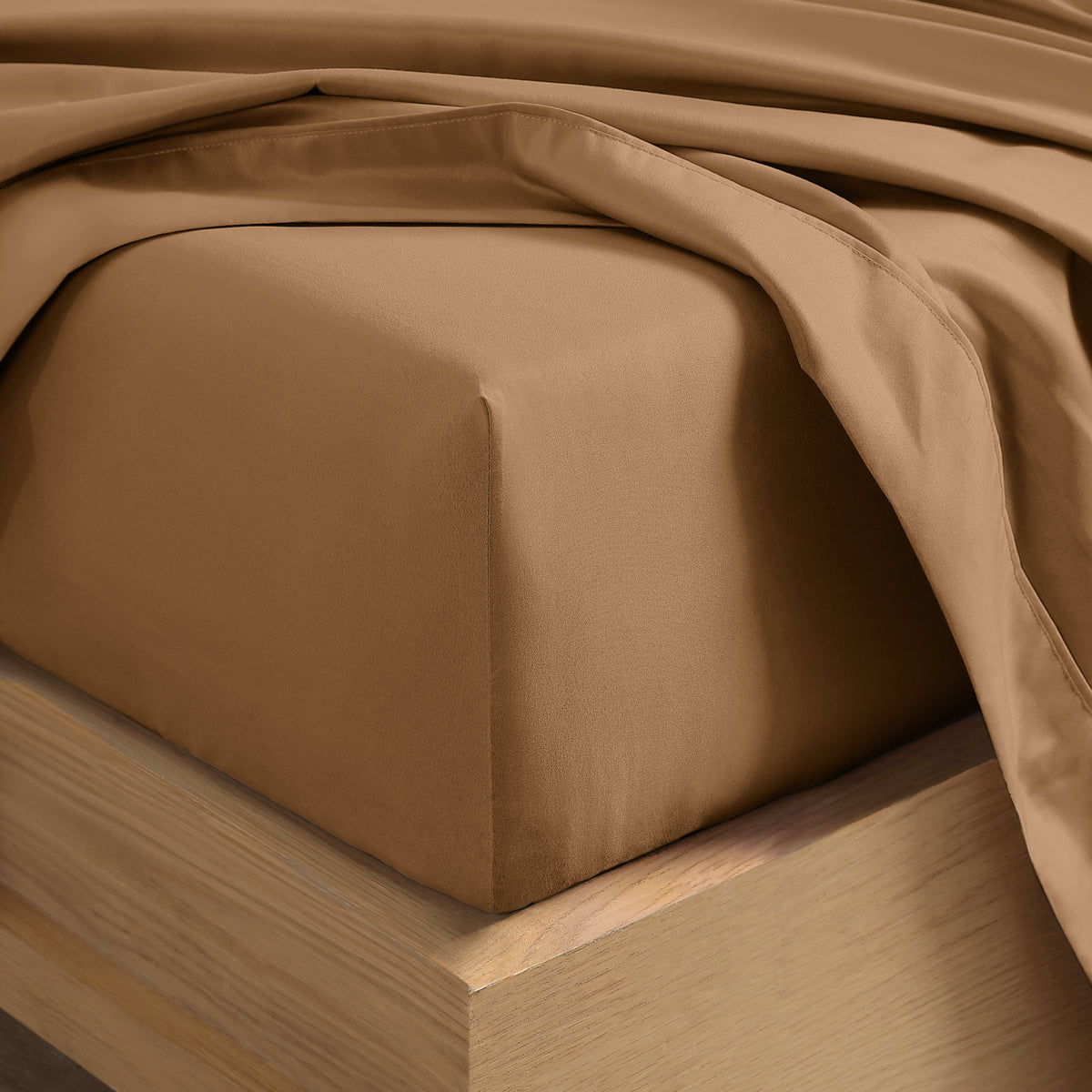 Close up of the corner of a mattress with a fitted sheet and flat sheet on it