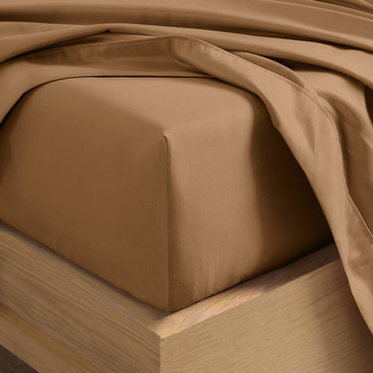 Close up of the corner of a mattress with a fitted sheet and flat sheet on it