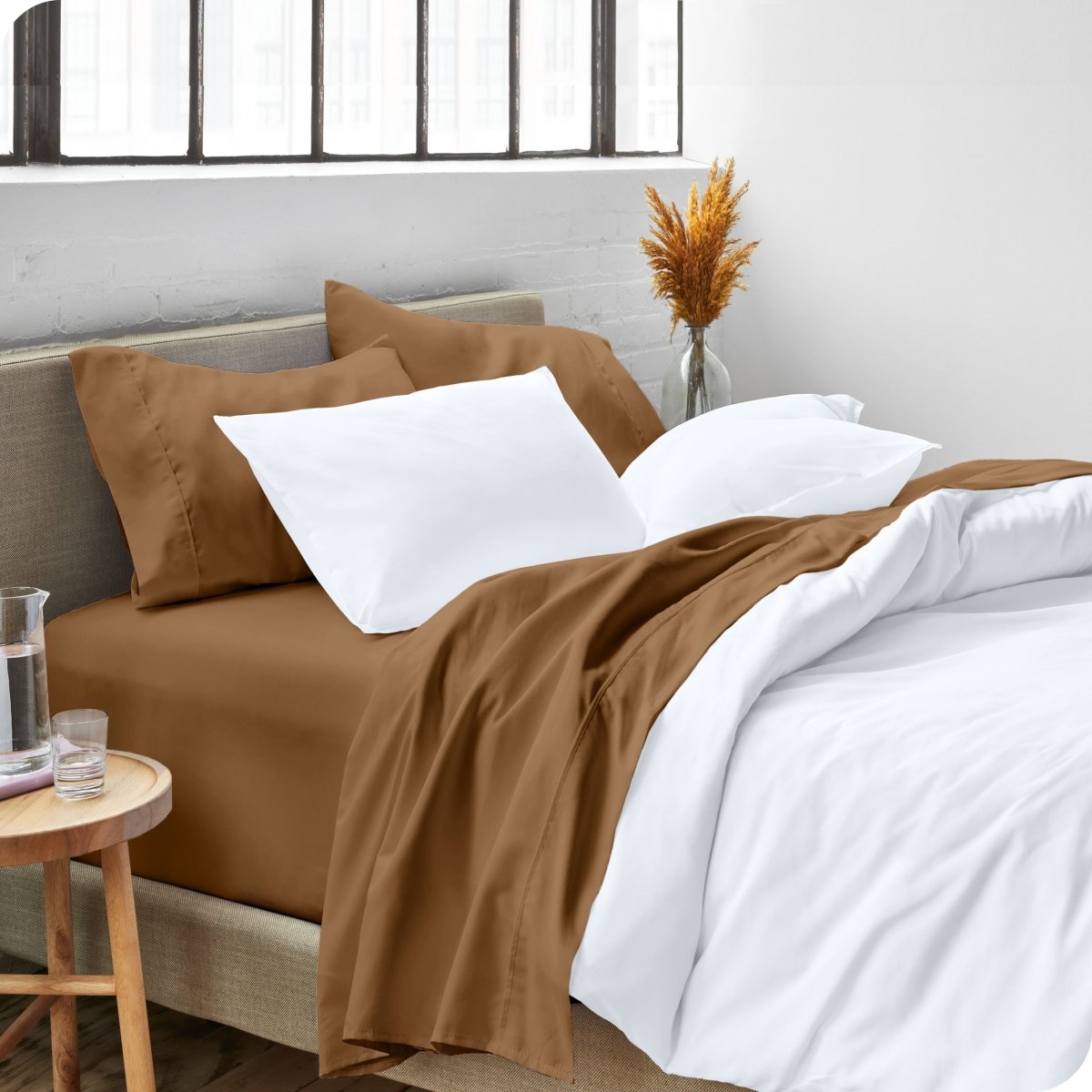 A side view of a bed made with microfiber sheets and a white duvet cover