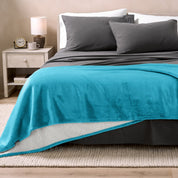 Bed with grey sheets and a sherpa blanket