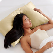 A woman is sleeping on a pillow with a satin pillowcase