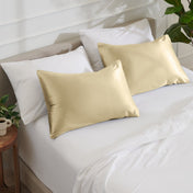 Satin pillowcases on a bed with white bedding