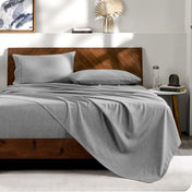 View from the end of a bed with matching sheets and pillowcases.