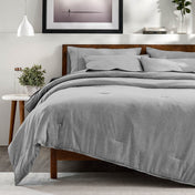 A bedroom with a side table, decor and a neatly made bed