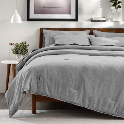 A bedroom with a side table, decor and a neatly made bed