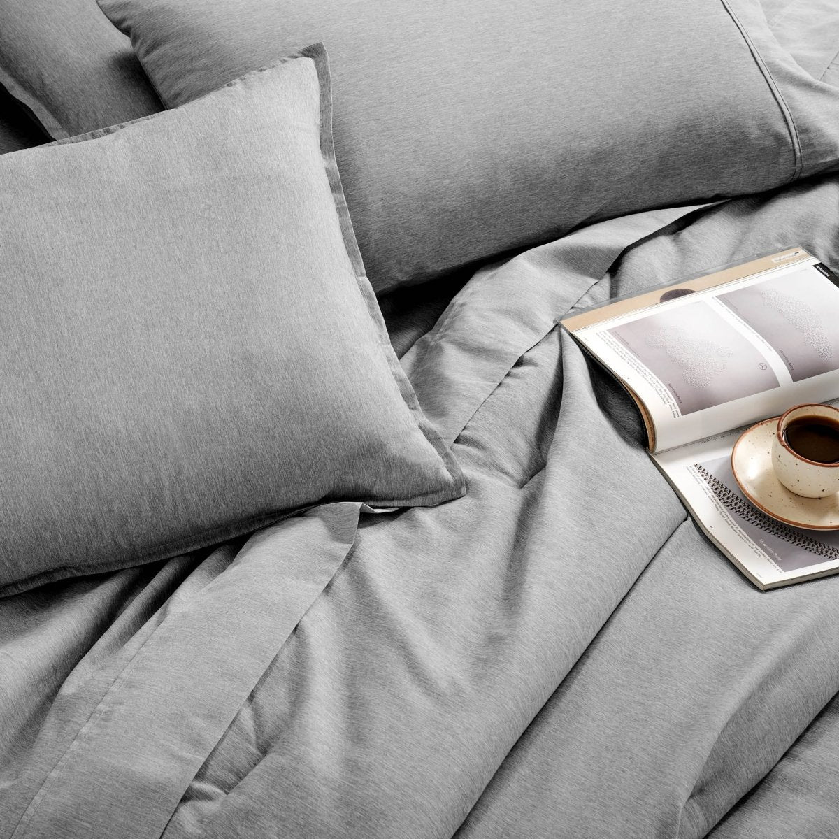 Bedding set with an open book and a cup on a saucer.