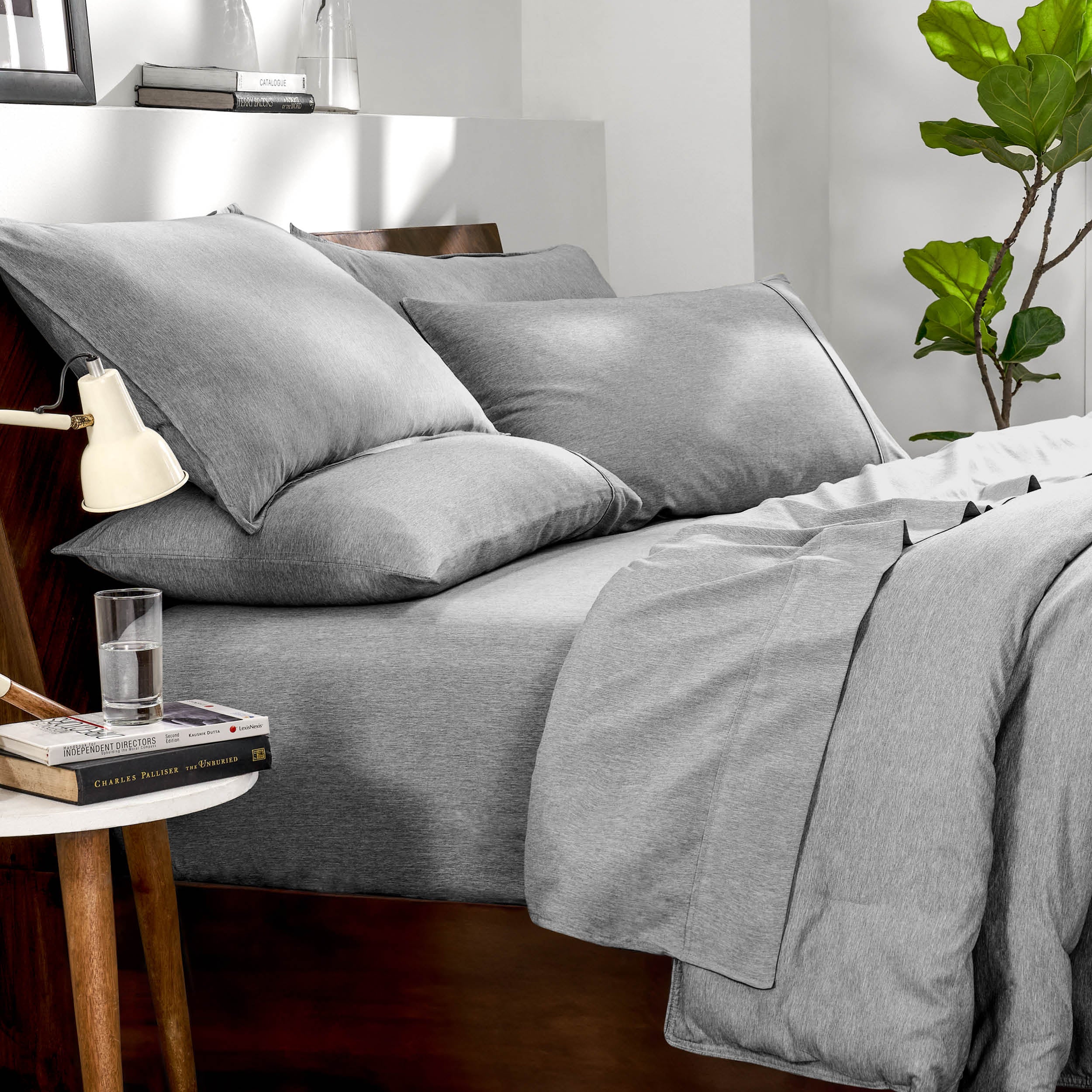 Bedding set on a bed in a bedroom with a side table and lamp.