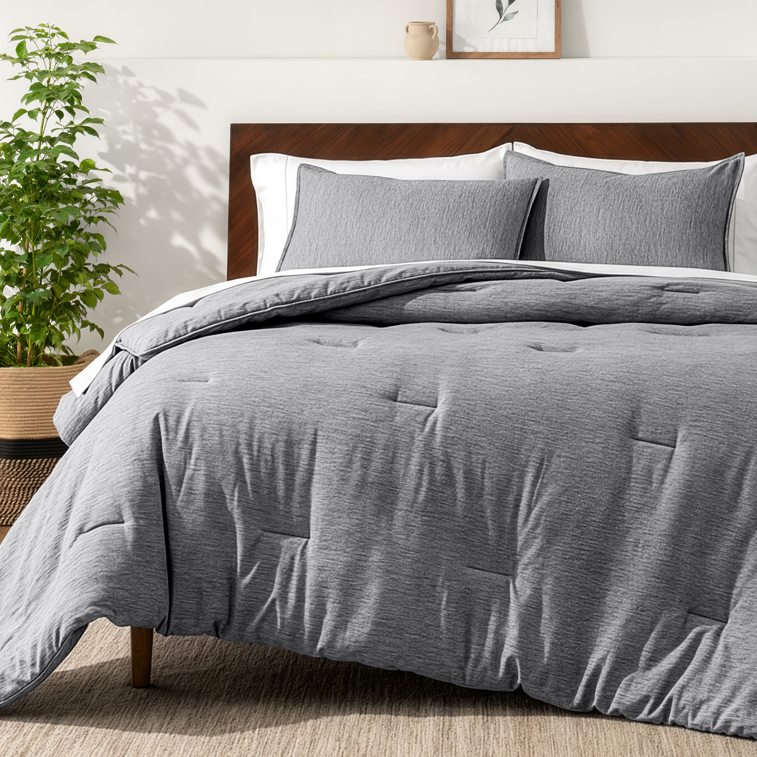 Bedding set on a bed in a bedroom with a side table and lamp.