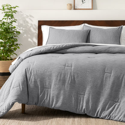 Bedding set on a bed in a bedroom with a side table and lamp.