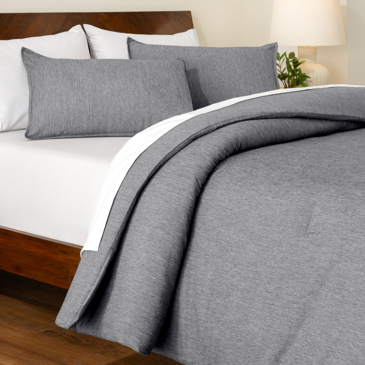Track stitch comforter on a bed with white pillows and a wooden headboard.