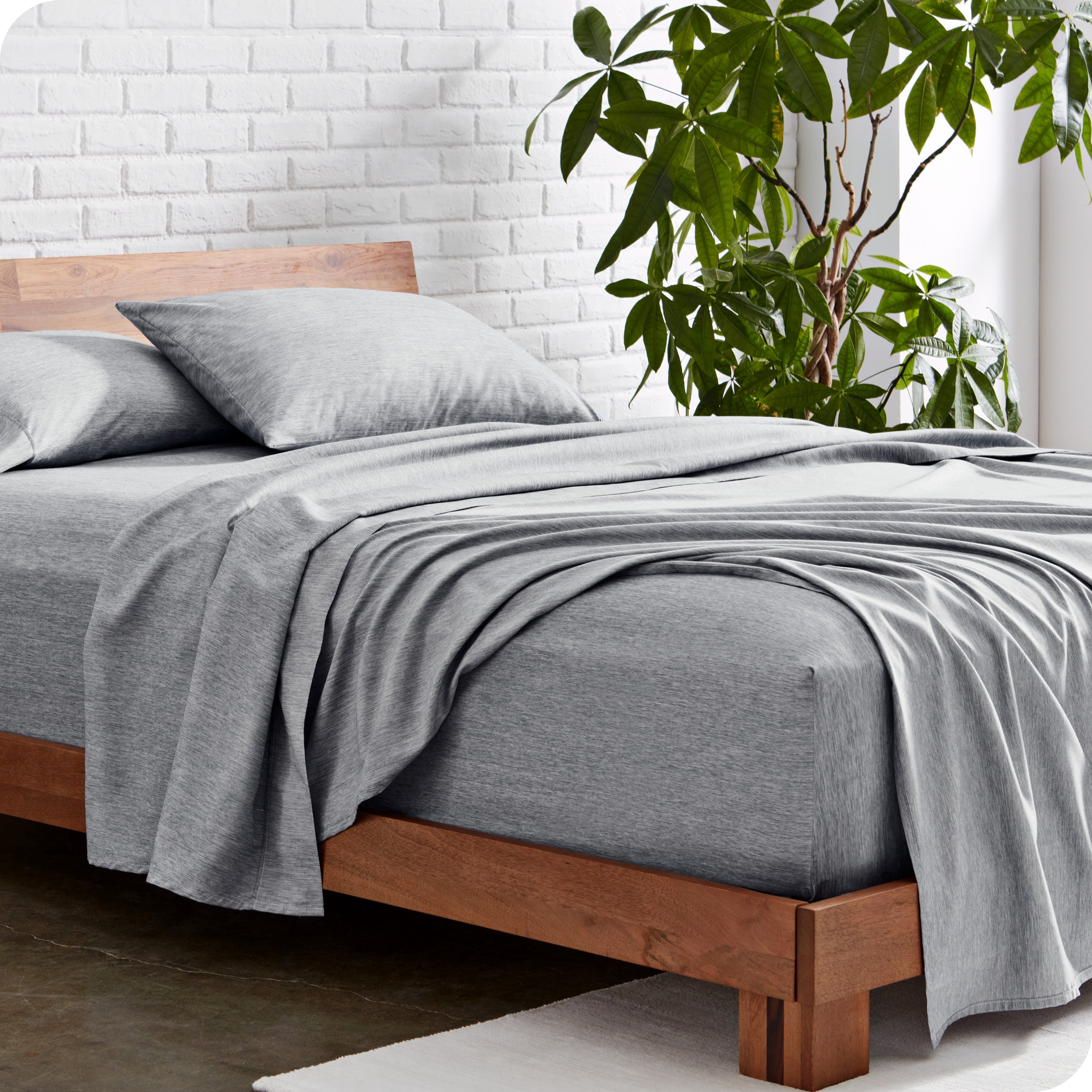 A side view of a bed with grey sheets