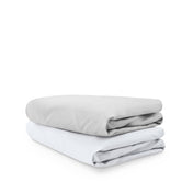 Stack of folded crib sheets on a white background