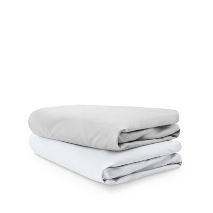 Stack of folded crib sheets on a white background