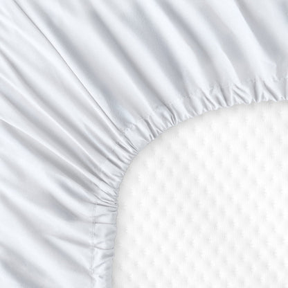 The back of a crib mattress with a fitted sheet on it