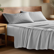 Bamboo bed sheets on a bed in a bedroom with night stands.