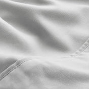 A close-up of microfiber fabric with soft folds and a visible stitched seam.
