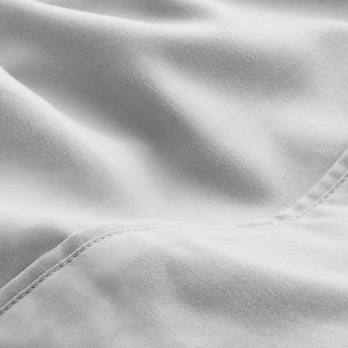 A close-up of microfiber fabric with soft folds and a visible stitched seam.