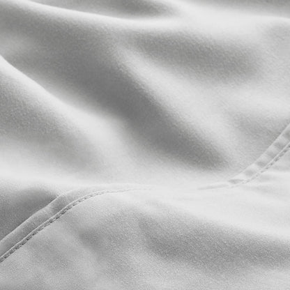 A close-up of microfiber fabric with soft folds and a visible stitched seam.