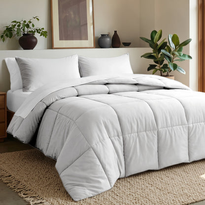 Comforter set on a bed in a bedroom with plants and decor.
