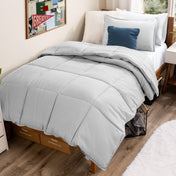 Bed with comforter and pillows in a dorm room
