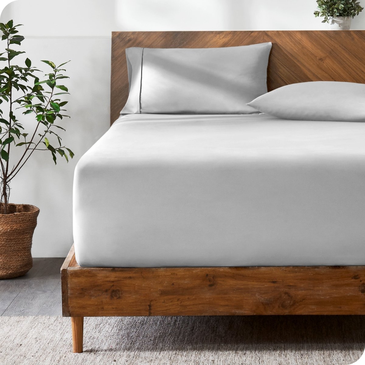 Wooden bed with ultra soft bedding in a minimalistic room.