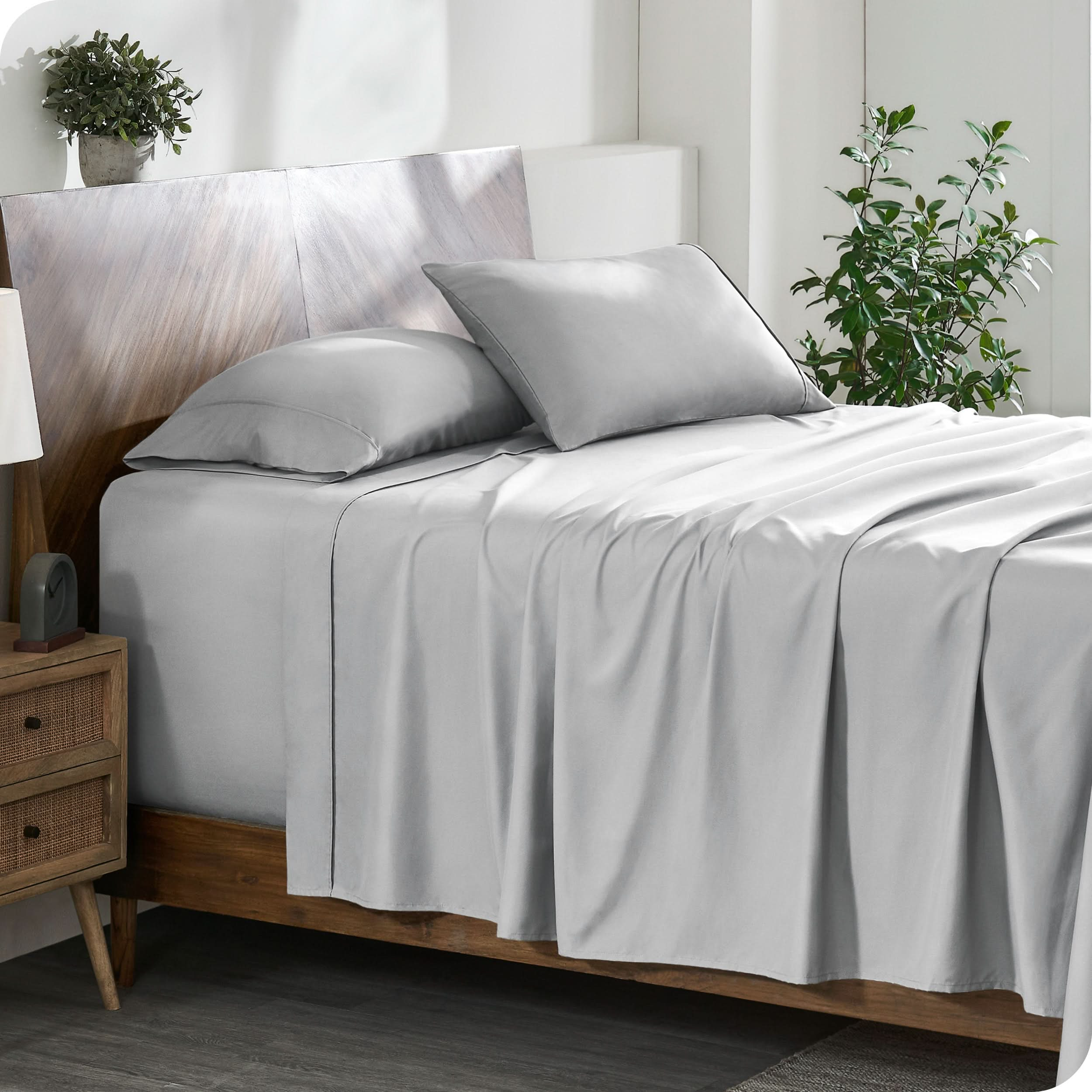 A cozy bedroom featuring a neatly made bed with soft, microfiber sheets.