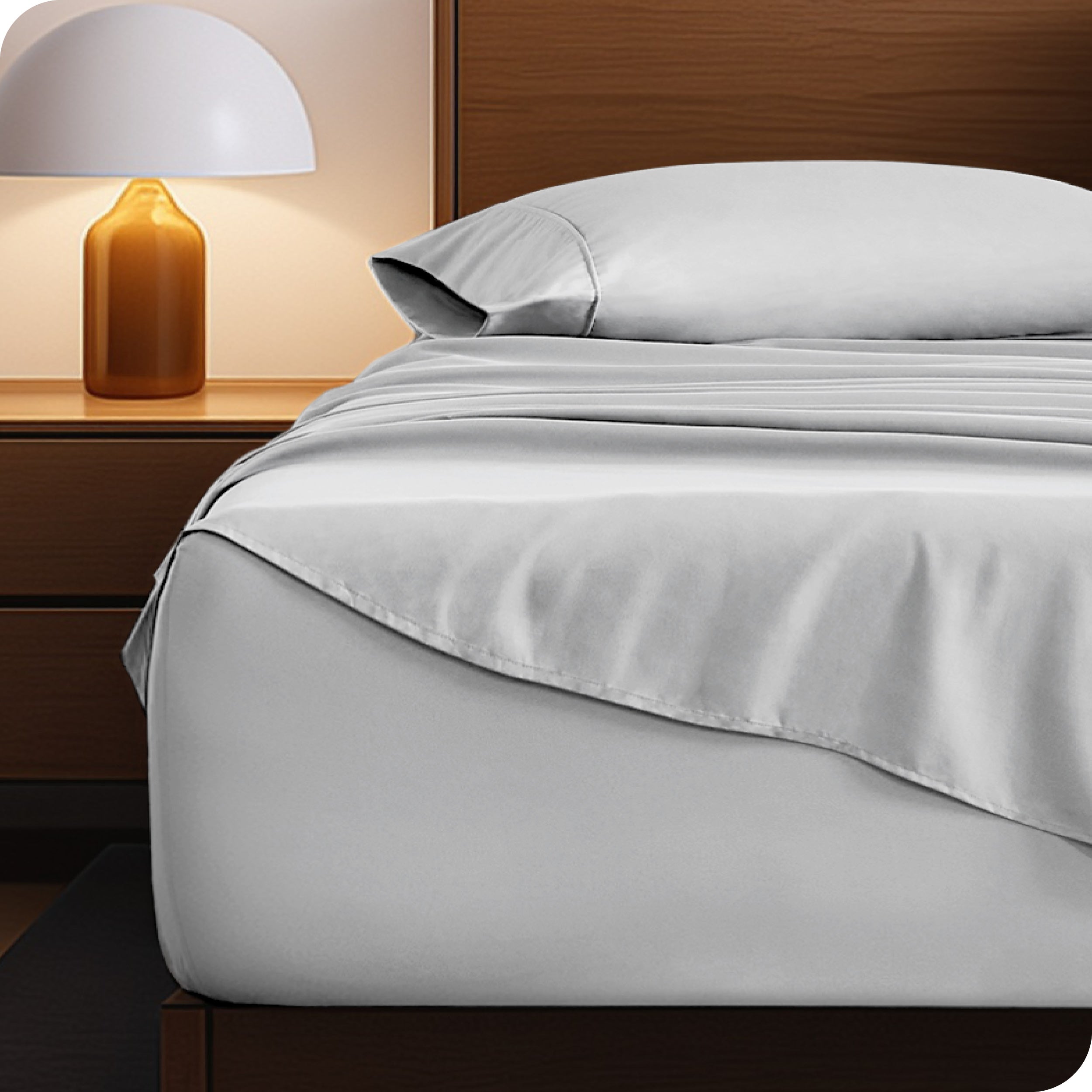 Microfiber bed sheets on a neatly made bed with a wooden headboard and nightstand.
