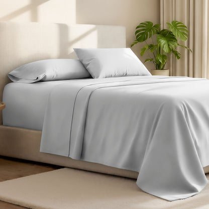Microfiber bed sheets on a neatly made bed with a wooden headboard and nightstand.