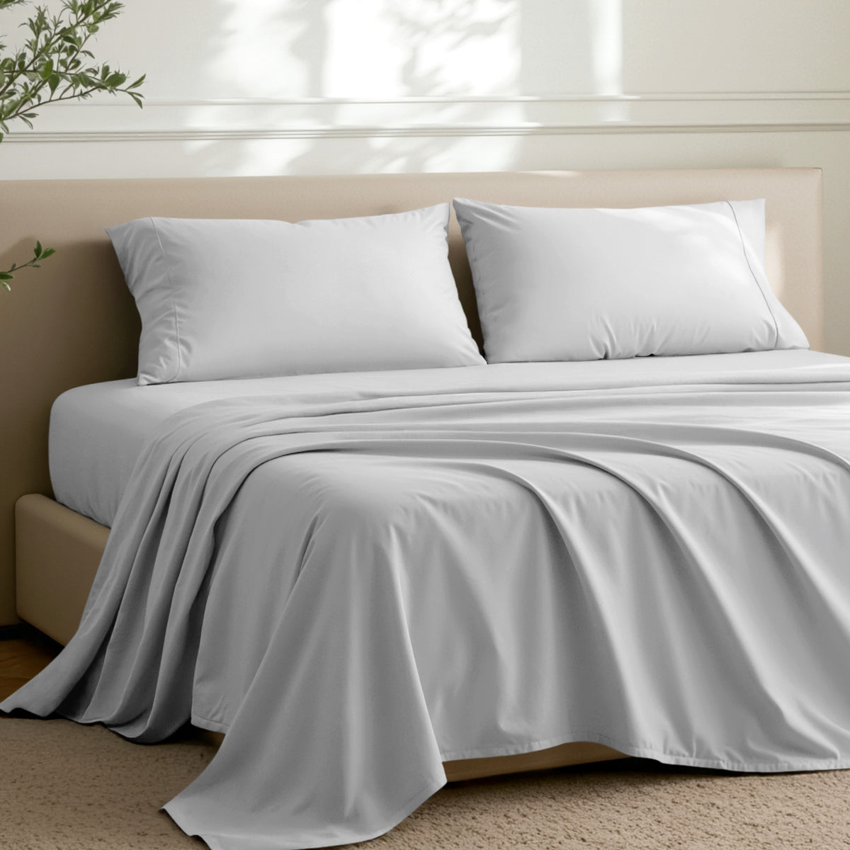 Microfiber sheets on a bed in a well-lit room with a plant.