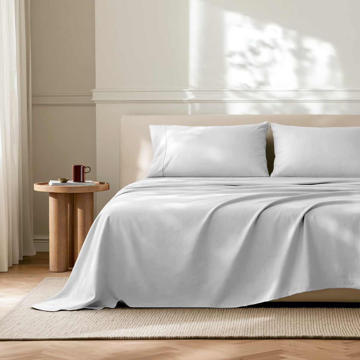 Neatly made bed with microfiber bedding in a bright bedroom.
