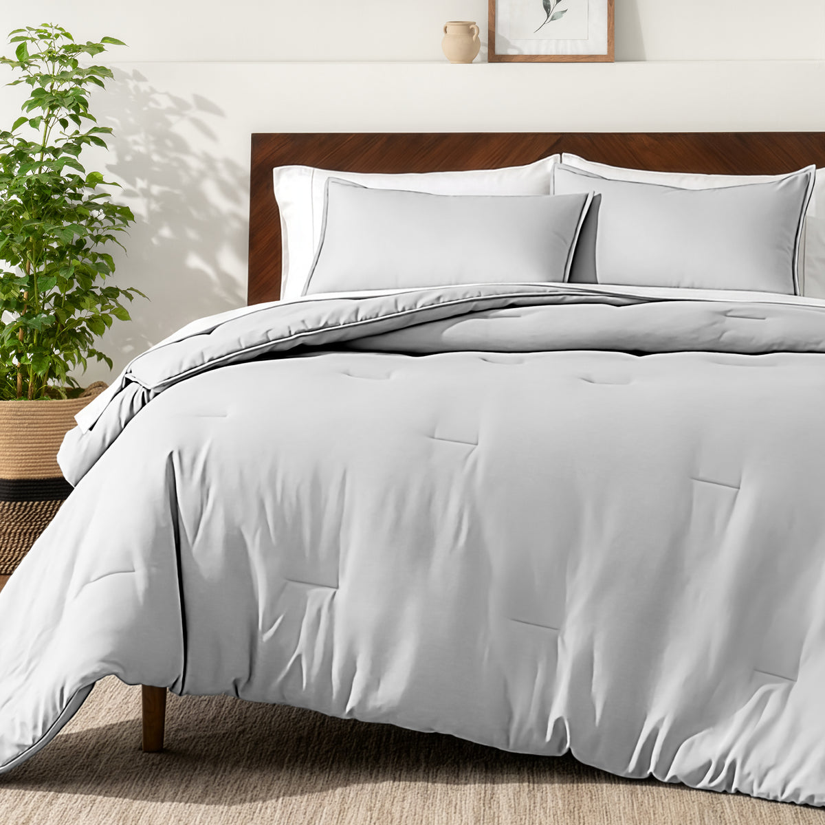 Bedding set on a bed in a bedroom with a side table and lamp.