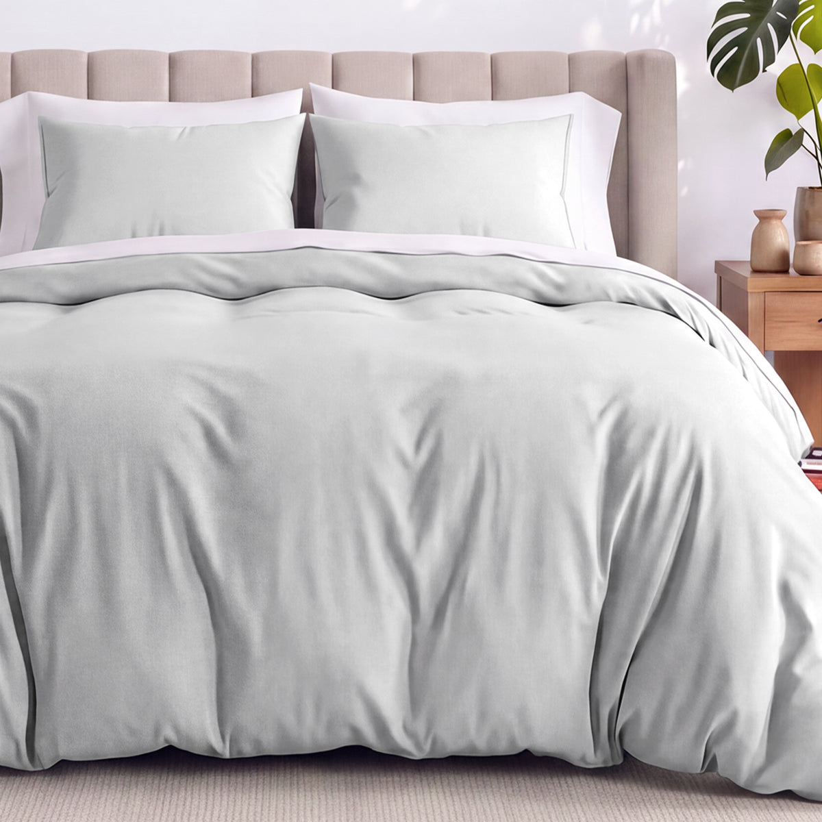 Neatly made bed with organic jersey bedding and pillow shams in a bedroom setting.