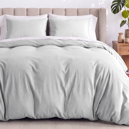 Neatly made bed with organic jersey bedding and pillow shams in a bedroom setting.