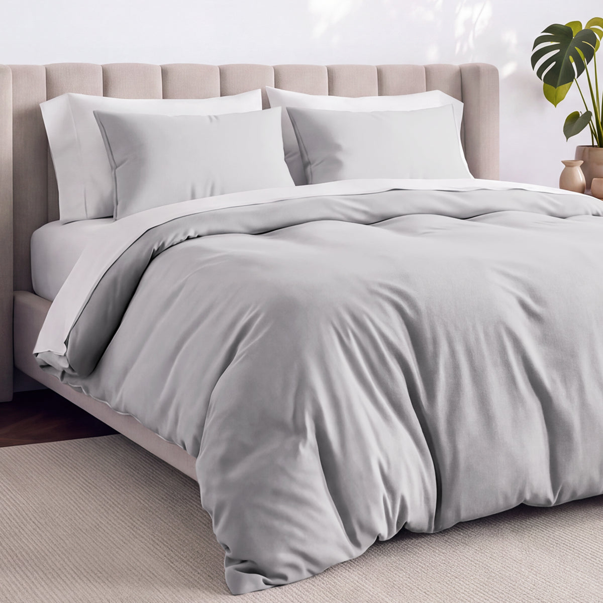 Bed with jersey duvet set against a beige headboard.