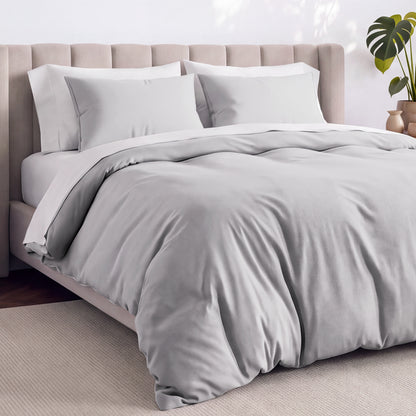 Bed with jersey duvet set against a beige headboard.