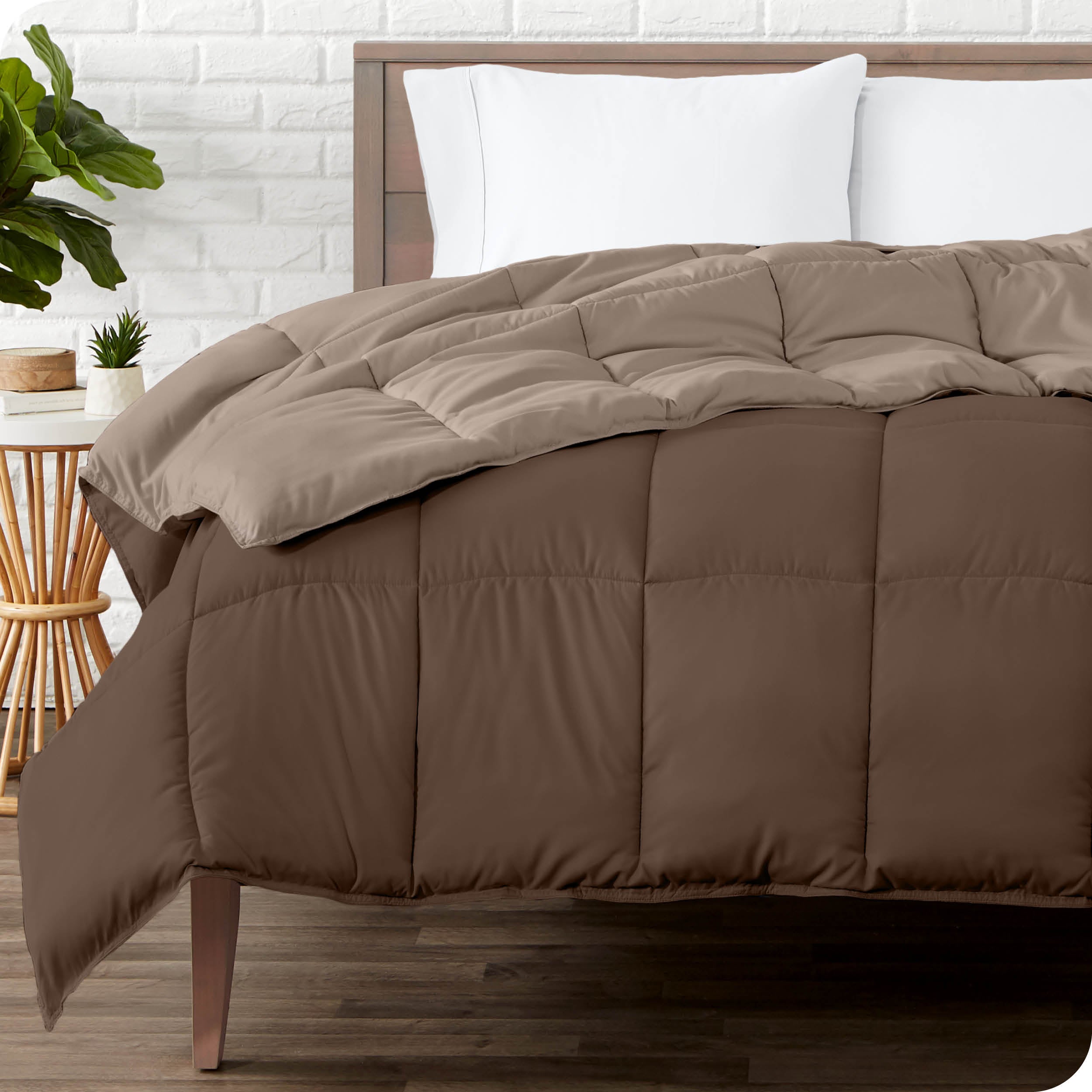 Wooden bed frame with a reversible comforter on the mattress. The comforter is folded back showing the two different colored sides.