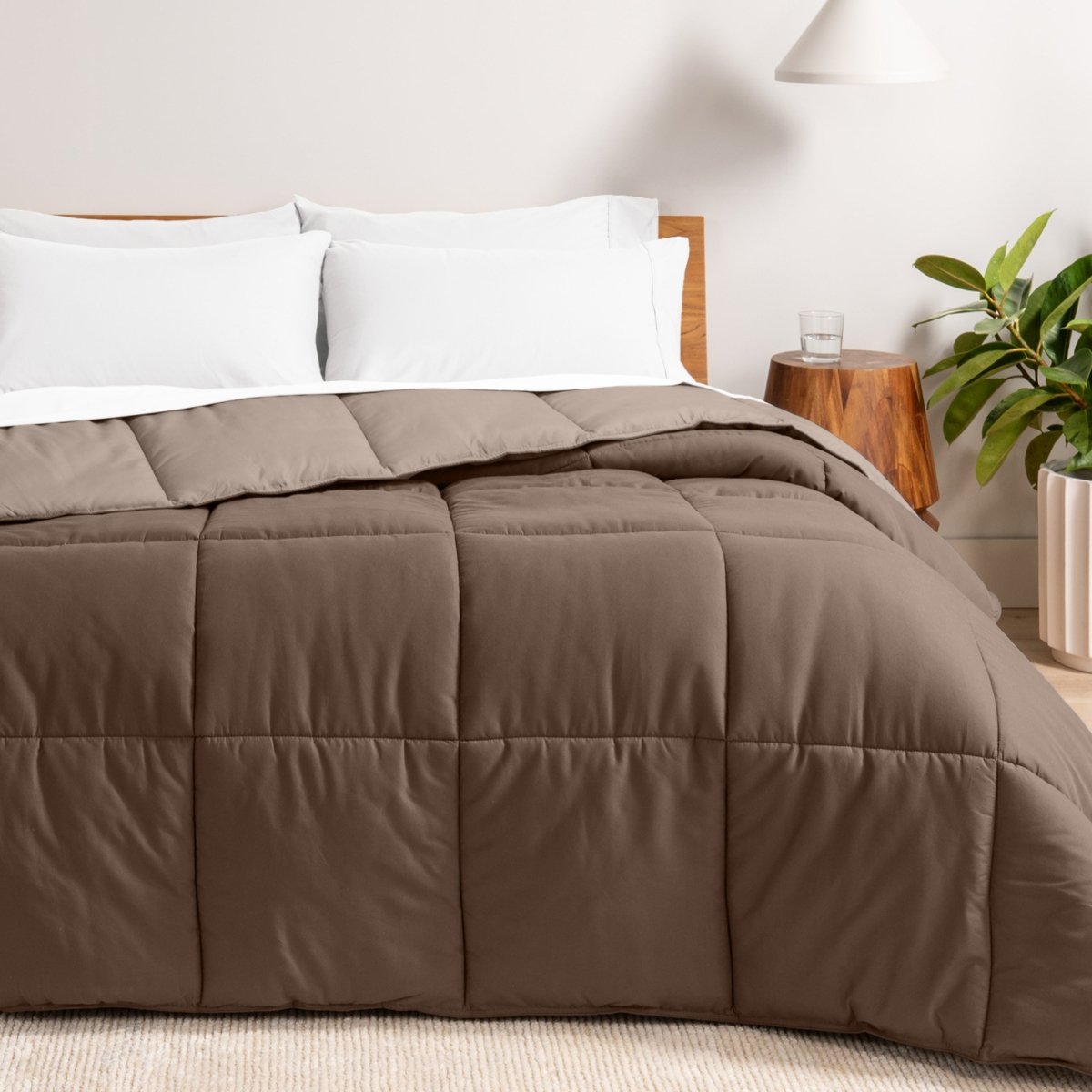 Bed with reversible comforter and white pillows in a bedroom setting