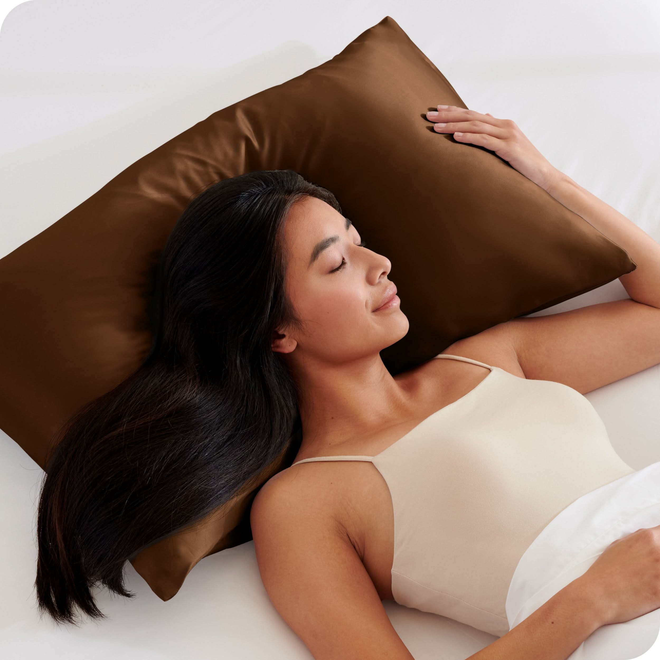 A woman is sleeping with her head on a silk pillowcase