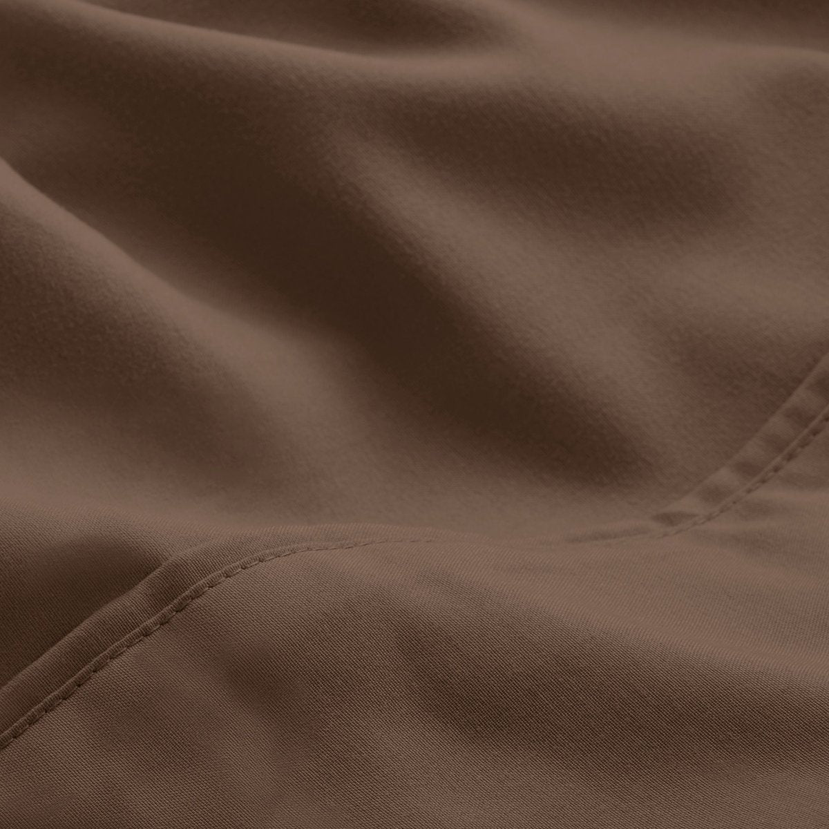 A close-up of microfiber fabric with soft folds and a visible stitched seam.
