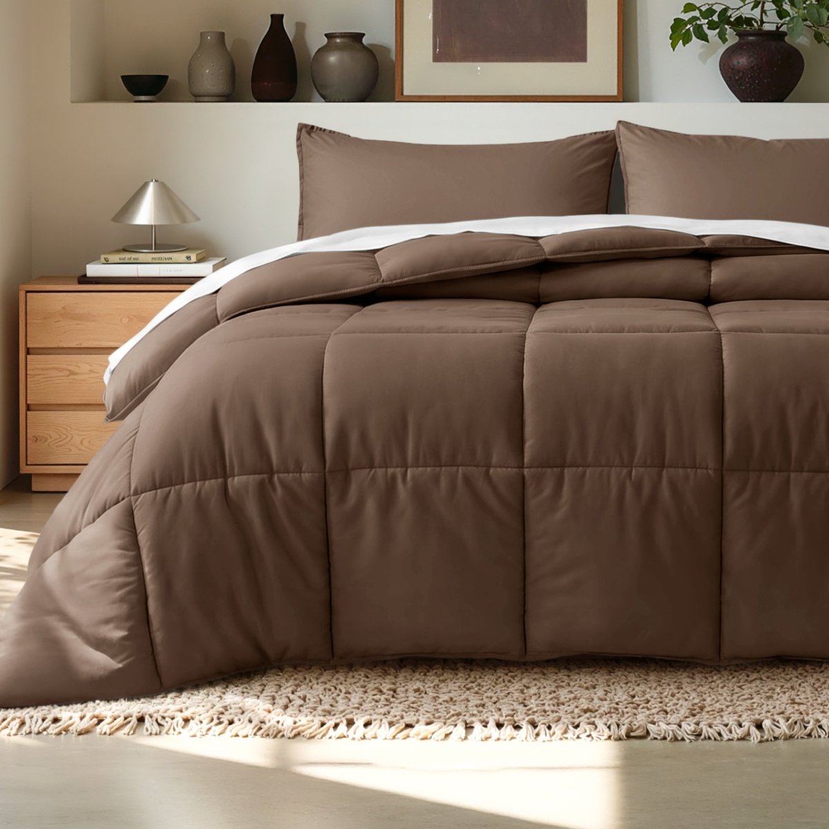 Comforter on a bed in a bedroom setting with a wooden nightstand and decorative items.