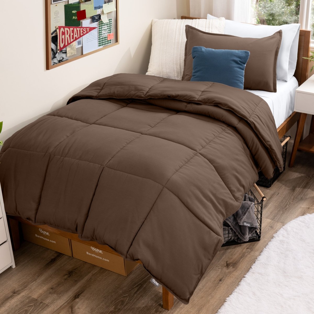 Bed with comforter and pillows in a dorm room