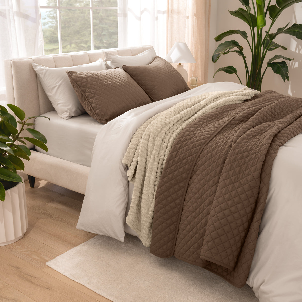 Side view of bed with coverlet set draped on a bed made with a duvet set